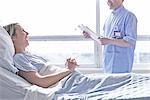 Patient lying in hospital bed laughing with nurse