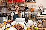 Young woman behind kitchen counter in cafe