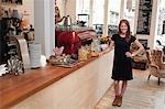 Portrait of young woman standing at cafe counter