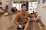 Portrait of young man with coffee and digital tablet in cafe