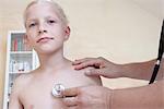 Boy being examining by doctor with stethoscope