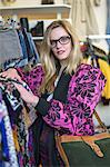 Woman looking through rails in clothes shop