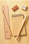 notebook, ruler and pencils on wooden background, studio shot