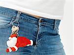 Close-up of waist with keychain shaped as Santa Clause hanging from belt loop, studio shot