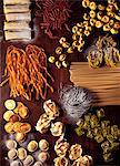 Assorted types of pasta on a wooden board