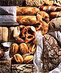 Assorted breads, rolls, pretzels and croissants on baking parchment