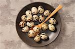 Quail's eggs in a bowl with a wooden spoon