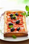 Puff pastry tart with cherry tomatoes, olives and oregano