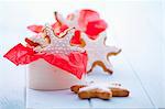 Gingerbread stars garnished with icing in a wooden box and around it