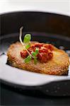 Breaded pork chop with tomato sauce and oregano