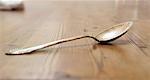 A silver spoon on a wooden table