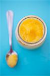 Lemon curd in a jar and on a spoon