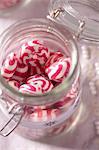 Red and white peppermint sweets in a storage jar