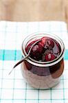 Chocolate mousse with stewed cherries in a small preserving jar