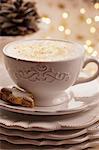 Cappuccino with gold sprinkles and a star-shaped cinnamon biscuit