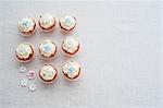 Eight cupcakes decorated with sugar flowers (view from above)