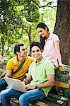 Friends using a laptop in a park, Lodi Gardens, New Delhi, Delhi, India