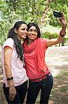 Friends taking a picture of themselves with a mobile phone, Lodi Gardens, New Delhi, Delhi, India