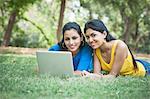 Friends using a laptop in a park, Lodi Gardens, New Delhi, Delhi, India