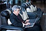 Businessman working on a laptop at an airport lounge