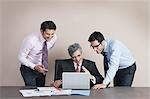 Business executives looking at a laptop and smiling