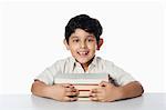 Boy leaning on books and smiling