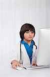 Boy using a desktop computer and imitating like a doctor