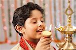 Boy burning oil lamps on Diwali