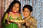 Children holding a plate of oil lamps on Diwali