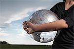 Girl holding transparent globe outdoors