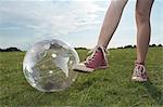 Girl standing in meadow with transparent globe