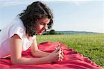 Girl lying on blanket in meadow