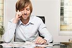 Smiling man at desk looking at banknotes