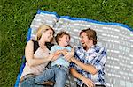 Happy family lying on blanket in meadow