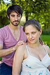 Man massaging pregnant woman's shoulders
