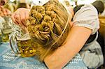 Exhausted woman with beer mug on the Oktoberfest in Munich, Bavaria, Germany