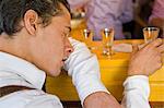 Exhausted man with shot glasses on the Oktoberfest in Munich, Bavaria, Germany