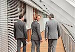 Three businessmen walking on corridor