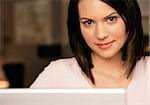 Smiling young woman using laptop, portrait