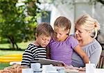 Mother with two children at garden table