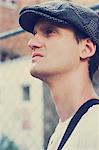 Pensive old-fashioned man standing at urban fence