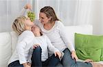 Mother and two children eating grapes on couch