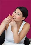 Young woman eating slice of pizza