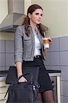Businesswoman in kitchen with a Latte Macchiato