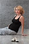 Smiling pregnant woman sitting on floor