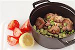 Adding the fava beans,peas and artichokes to the casserole dish