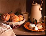 Basket of small breads and a plate of cheeses