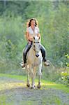 Portrait of young woman riding a white, Bavarian Warmblood horse, Bavaria, Germany