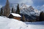 A snow covered wooden barn at the Alta Badia ski resort with Lavarella and Contourines mountains, Corvara, The Dolomites, South Tyrol, Italy, Europe