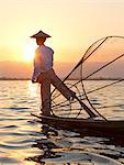 Intha 'leg rowing' fishermen sunset on Inle Lake who row traditional wooden boats using their leg and fish using nets stretched over conical bamboo frames, Inle Lake, Myanmar (Burma), Southeast Asia